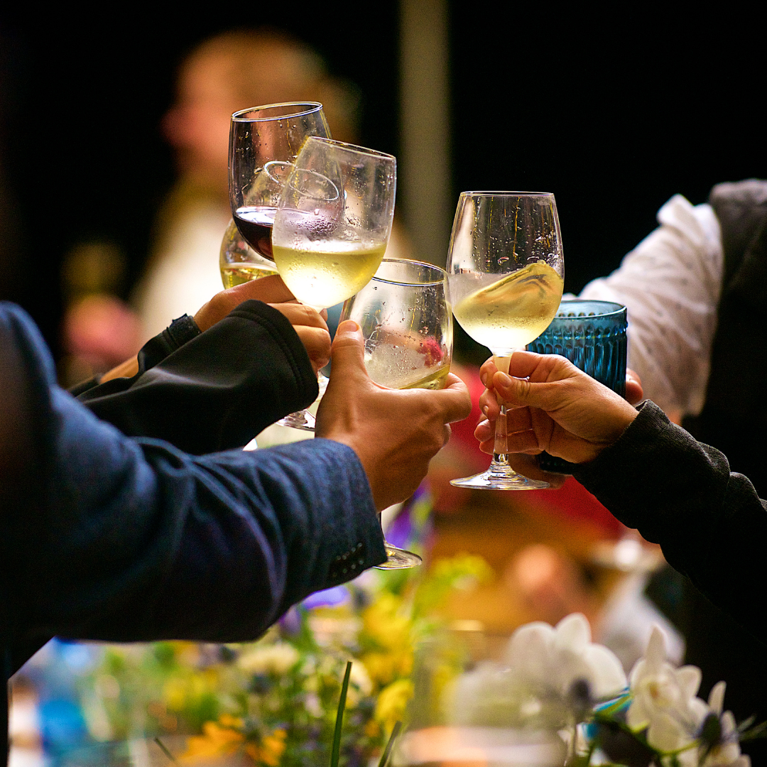 Glasses of white and red wine going in for a toast